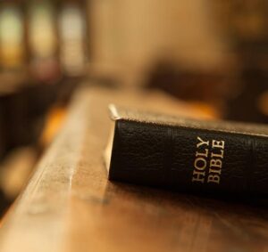 bible sitting on a wooden pew