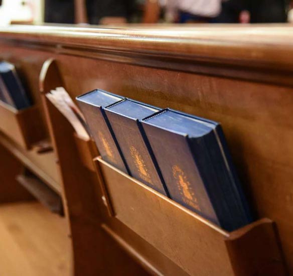 hymnals in the back of a pew