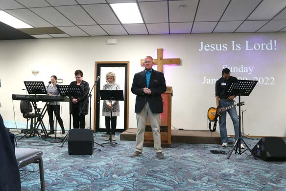 pastor Kevin standing with the worship team 